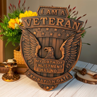 A carved wooden plaque featuring a patriotic design with a bald eagle, American flag stripes, stars, and engraved text that reads "I AM A VETERAN MY OATH OF ENLISTMENT HAS NO EXPIRATION DATE"