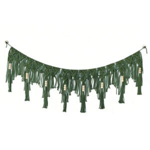 A green macrame garland hanging in a curved drape against a white background, featuring intricate woven knot patterns, cascading fringe, and natural wooden bead accents
