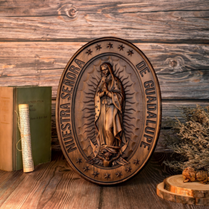 Oval carved wooden relief plaque of Our Lady of Guadalupe with Nuestra Señora De Guadalupe inscription on a rustic wooden desk