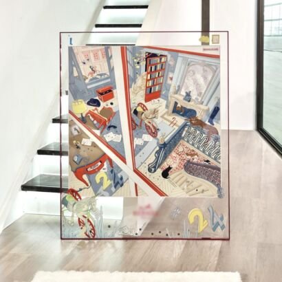 A large transparent acrylic art frame displayed on a light wooden floor by a staircase, featuring a framed silk scarf artwork depicting detailed architectural interiors, a red bookshelf, rocking horses, and vibrant graphic number 24 accents.