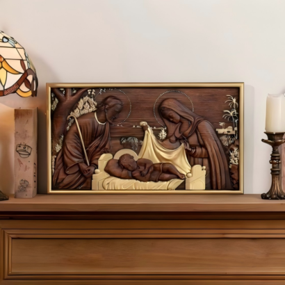 3D carved wooden relief artwork depicting Joseph, Mary, and baby Jesus in a cradle with a gold frame on a mantelpiece