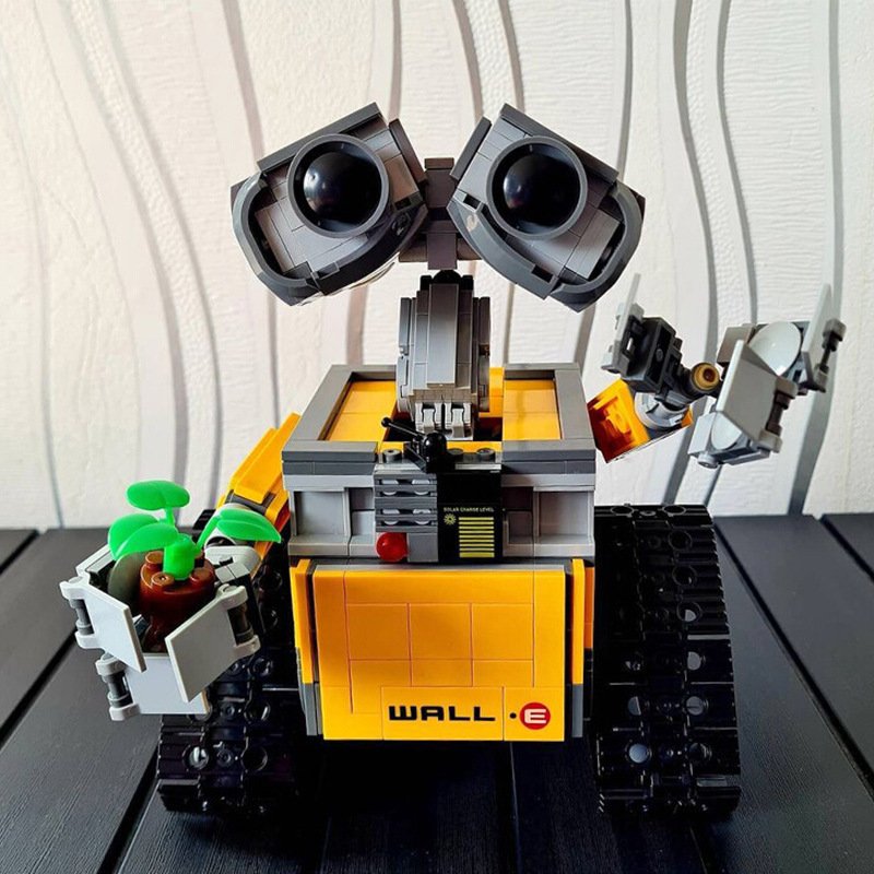 Building block WALL-E robot model from the animated movie, yellow tracked robot holding a sapling plant, movable head and arms