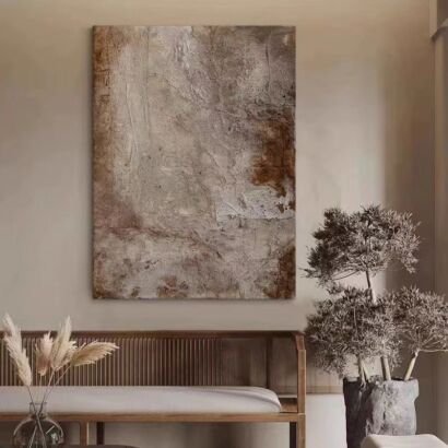 Vertical wabi-sabi textured abstract wall art in neutral beige and rust brown, hung above wooden bench in warm interior