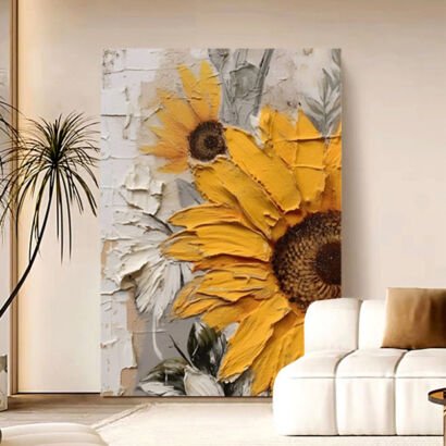 A large vertical 3D textured abstract canvas painting featuring vibrant yellow sunflowers and white blossoms with thick impasto plaster strokes, displayed in a modern beige living room behind a white sofa.