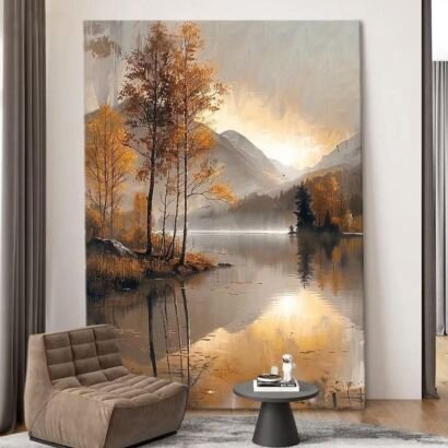 A large vertical canvas painting of a serene autumn lake landscape with golden trees, distant mountains, and soft sunlight reflecting on the water, displayed in a modern living room.