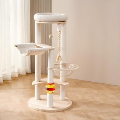 A modern light-wood multi-level cat tree featuring white sisal-wrapped scratching posts, a plush top bed, a clear acrylic space capsule bowl, a soft fabric hammock, a dangling rope with a ball toy, and a colorful multi-level track ball toy near the base, set on a wooden floor in a brightly lit room.