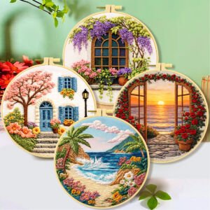 Four round wooden embroidery hoops displaying detailed 3D textured landscape embroidery scenes, including a sunset sea view arch, a cottage window with purple wisteria, a village house with pink cherry blossoms, and a tropical ocean beach with palm trees against a soft background.