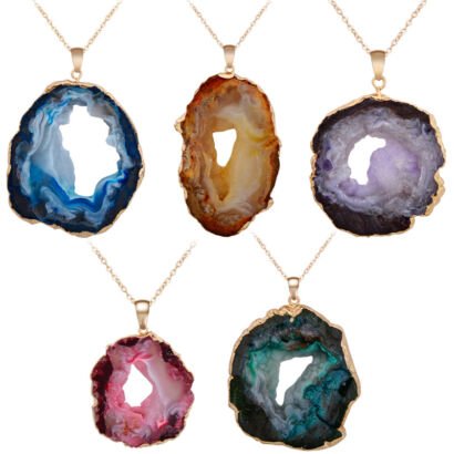 A display of five natural sliced agate geode pendant necklaces featuring hollow center openings, colorful bands in blue, amber-brown, purple, pink, and teal green, each edged in gold electroplating on a fine gold chain against a white background.
