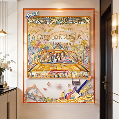A large transparent acrylic framed wall art display mounted on a white entryway wall, featuring a central silk scarf illustration of a yellow vintage convertible car with "City of Light" typography, surrounded by floating electric guitar, star, and horse graphics on the clear outer border with a vibrant orange frame.