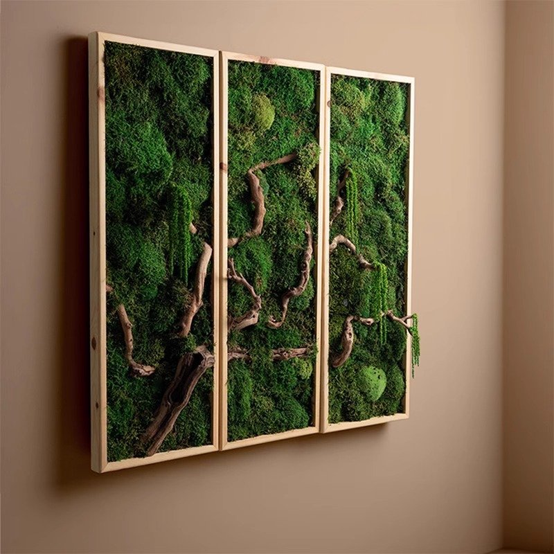 A triptych set of three vertical wooden framed wall art panels hanging on a warm beige wall, featuring lush preserved green moss and authentic gnarled wooden branches spanning across the multi-panel display.