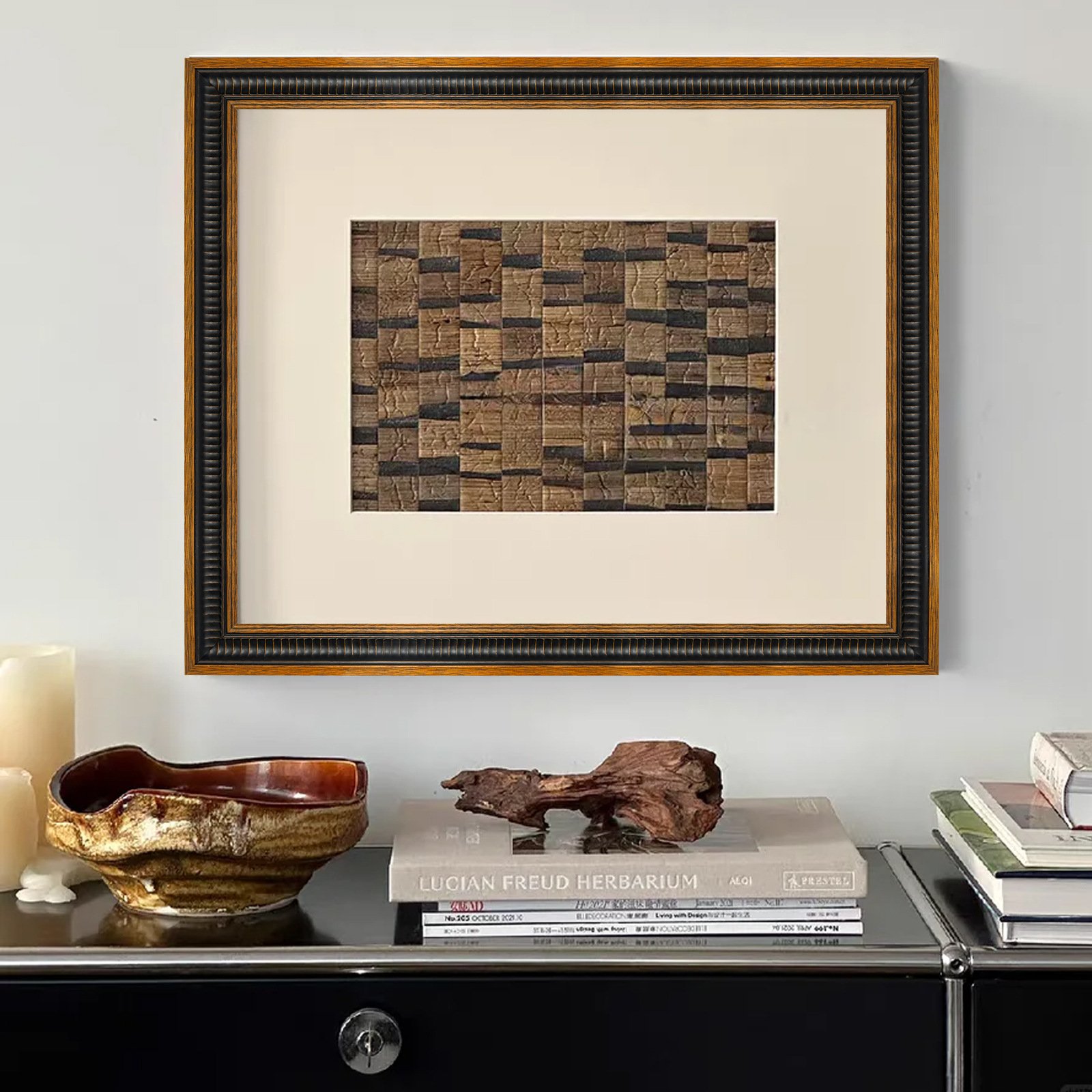 Framed textured woven wall art, neutral brown patchwork fiber artwork with vintage two-tone wood frame, hung above black console table
