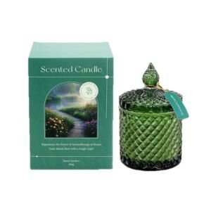 An elegant emerald green diamond-cut glass candle jar with a pointed decorative lid displayed alongside a matching green "Dawn Garden" gift box.