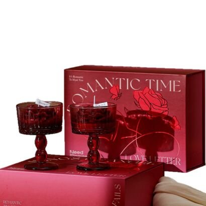 Two red ribbed glass goblet scented candles filled with dark red rose-shaped wax, displayed in front of a deep red "Romantic Time" gift box.