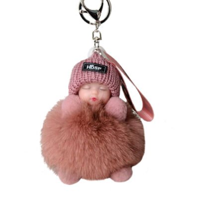A cute dusty rose pink plush keychain featuring a sleeping baby face wearing a knit beanie hat, resting on a fluffy faux-fur pom pom body with a silver keyring clasp.