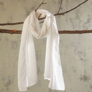 A lightweight, semi-sheer off-white silk chiffon scarf draped gracefully over a natural wooden tree branch against a textured neutral wall backdrop.