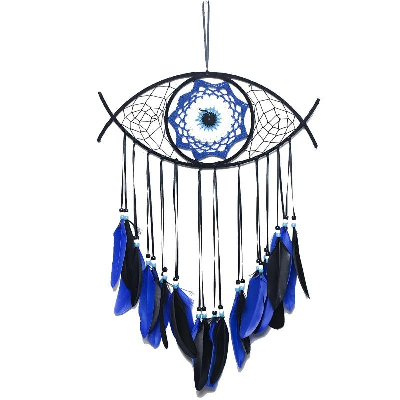 A detailed handmade dream catcher designed in the shape of an evil eye, featuring a central blue woven iris pattern, black outer web, and cascading blue and black feathers against a white background.