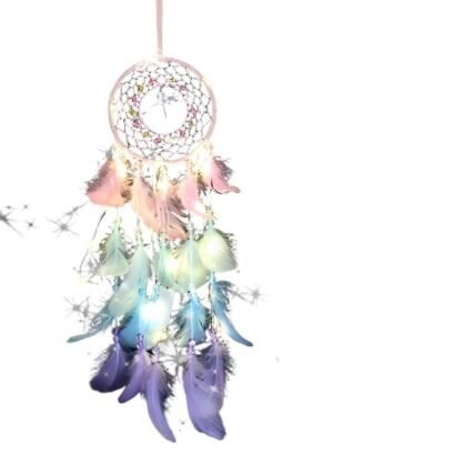 A delicate handmade dream catcher with a pink beaded web, warm LED lights, and cascading pastel pink, mint green, light blue, and purple feathers against a white background.